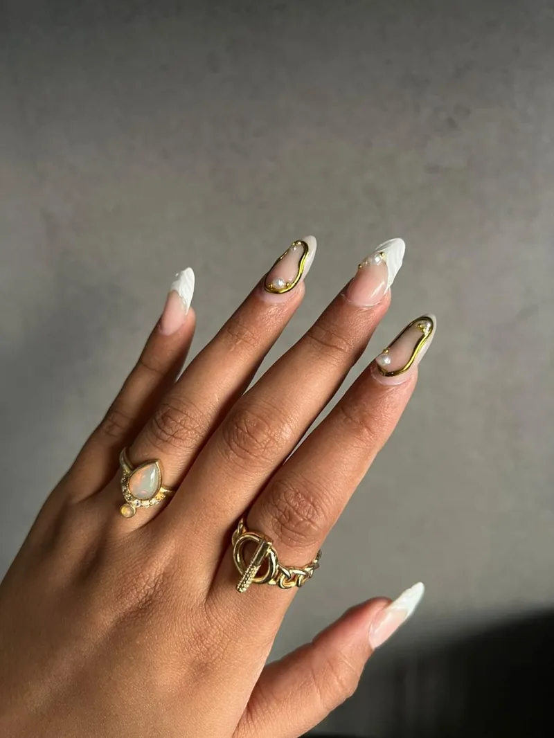 Sheer nude nails with 3D gold outline and pearl detail